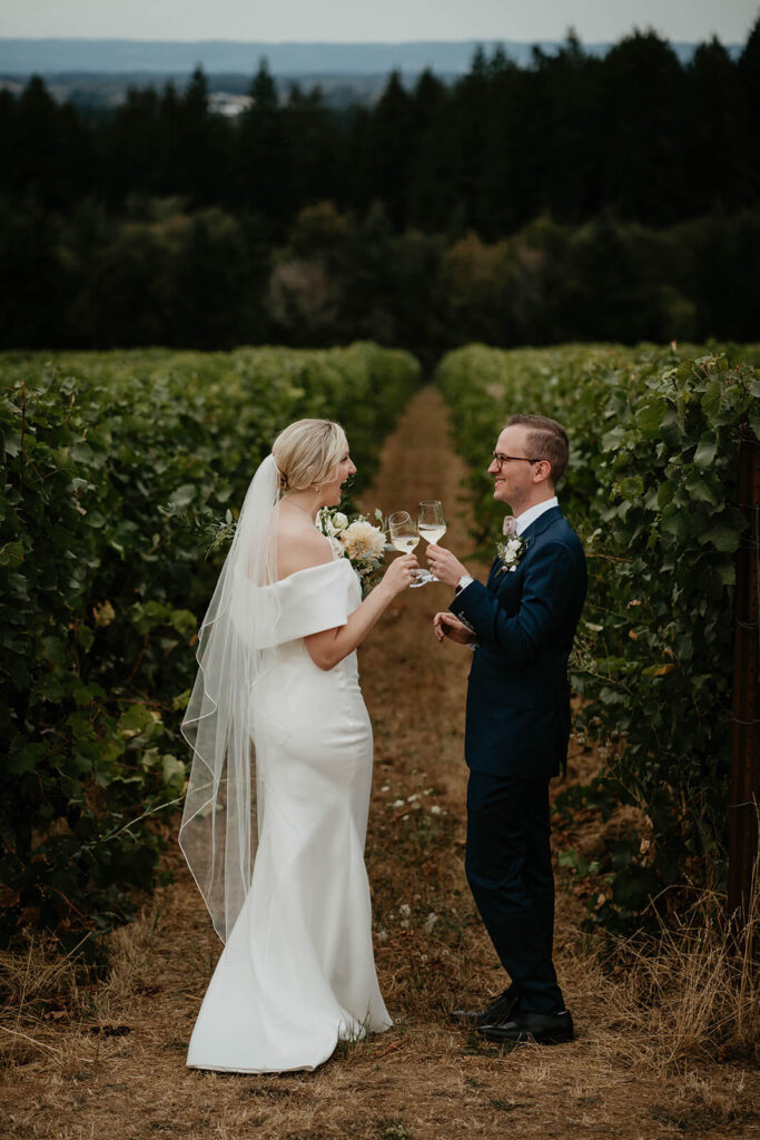 Bride and groom toast with wine in Ponzi Vineyards
