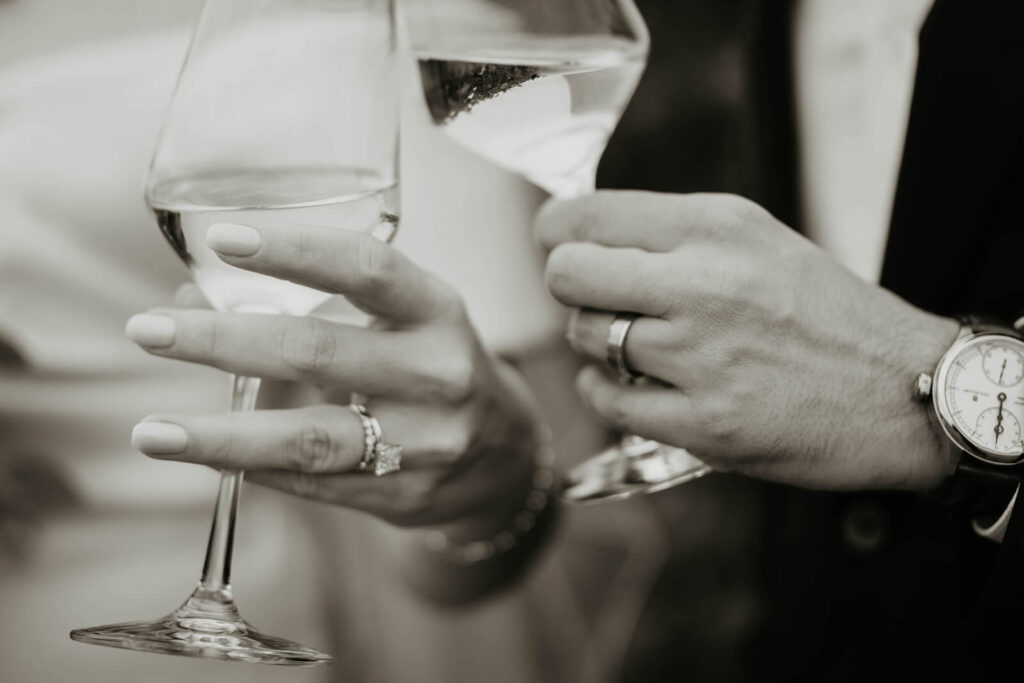 Bride and groom clink wine glasses at Ponzi Vineyards