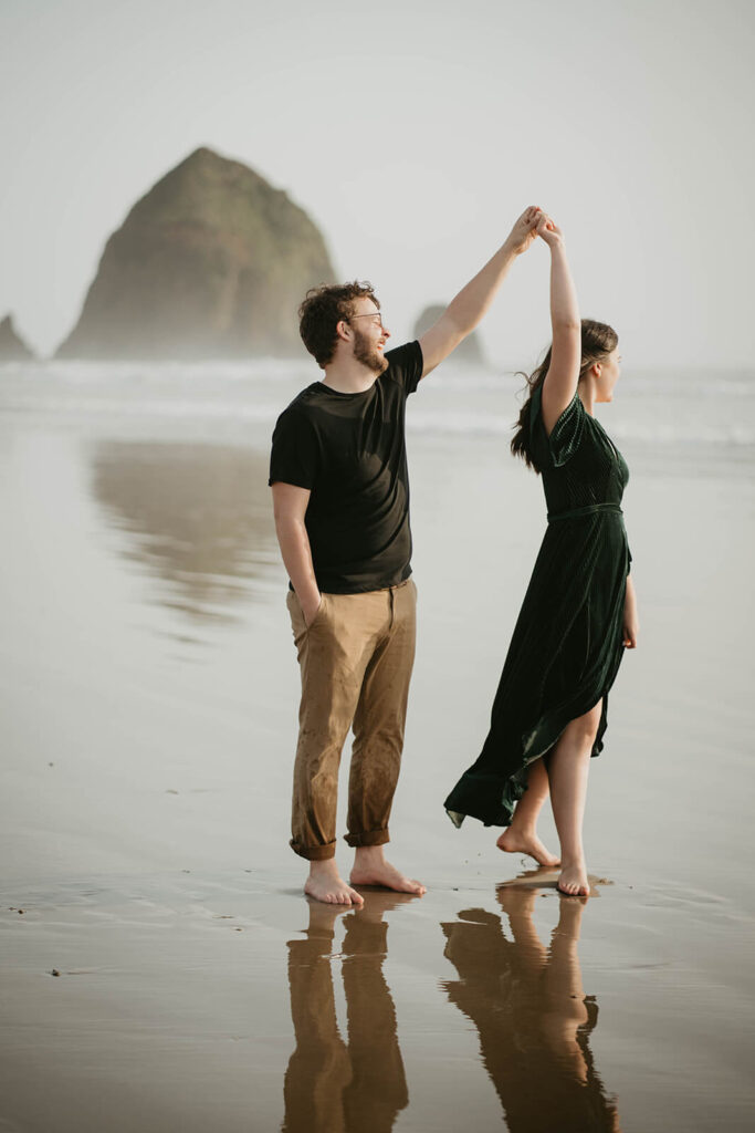 Couple dancing on Cannon Beach during their beach engagement photos