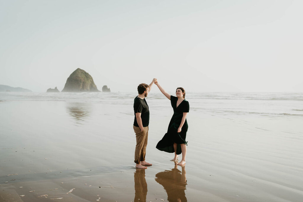 Couple dancing on Cannon Beach during their beach engagement photos