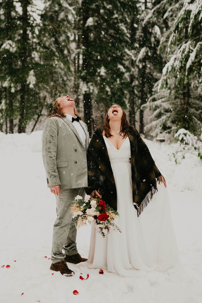 Brides licking the snow at their cozy Christmas cabin elopement