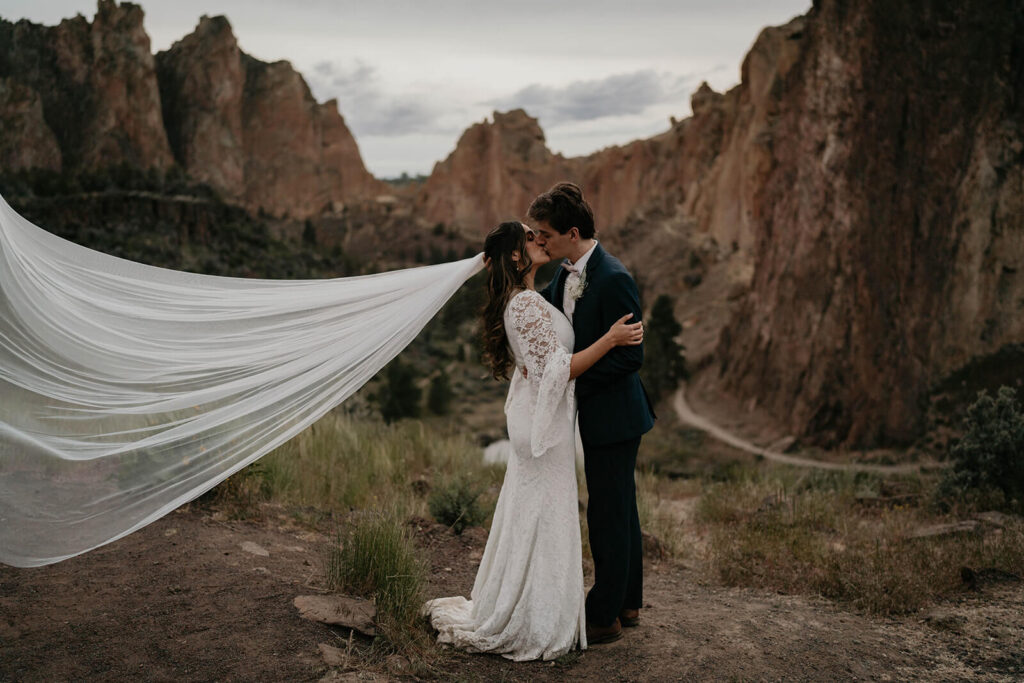 Bride and groom kissing at rock climbing elopement in Oregon