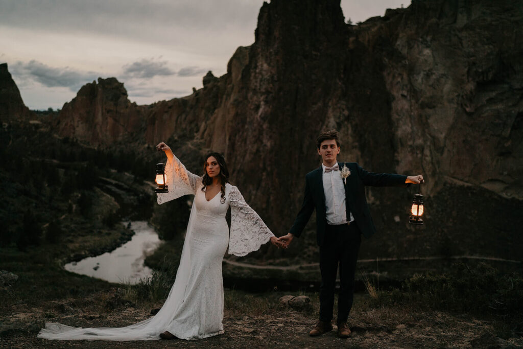 Bride and groom carrying lanterns at their adventure elopement at Smith Rock State Park