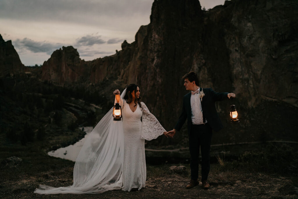 Bride and groom carrying lanterns at their adventure elopement at Smith Rock State Park
