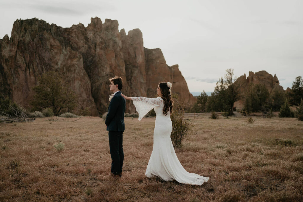 Bride and groom first look at boho elopement at Smith Rock State Park