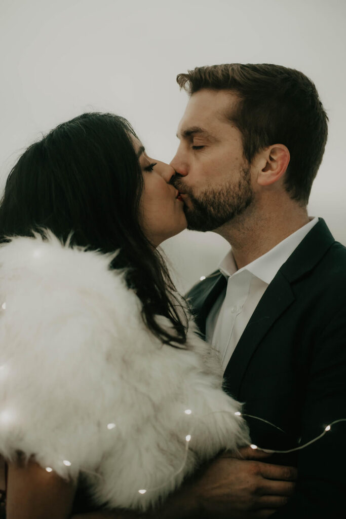 Couple kissing during snow engagement photos