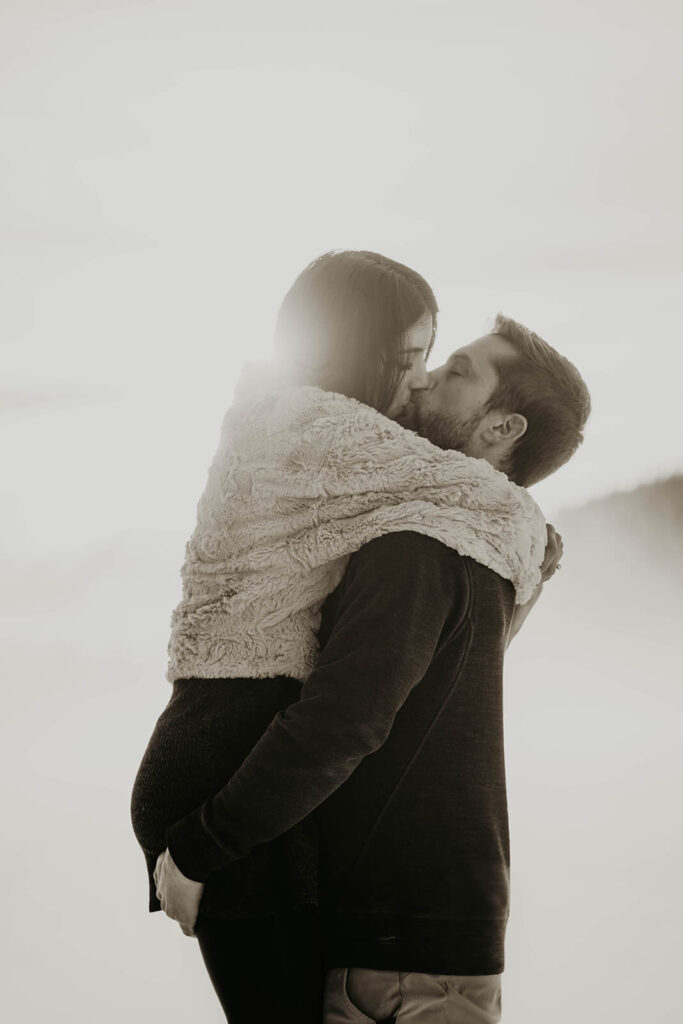 Couple kissing in the snow during engagement photo session
