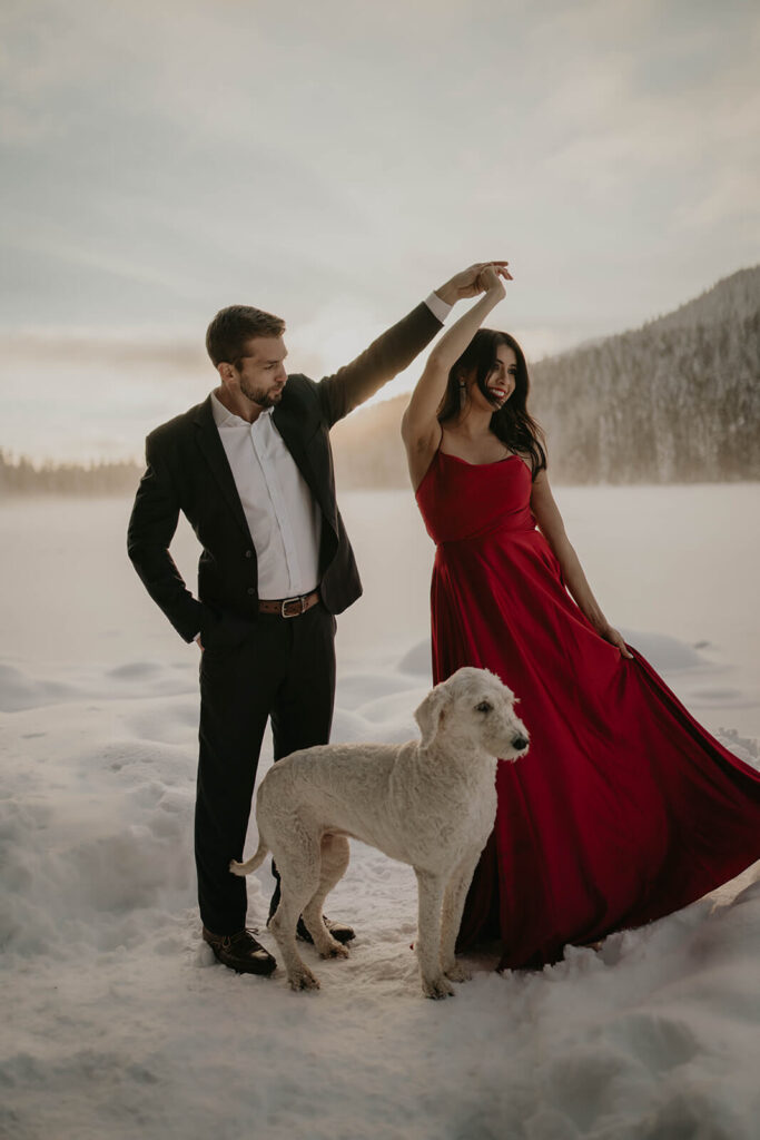 Man twirling woman in the snow during engagement photos
