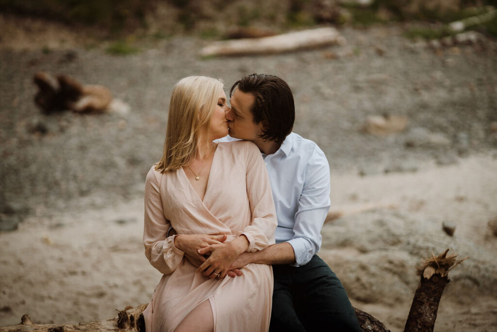Couple kissing during engagement photo session at Hug Point