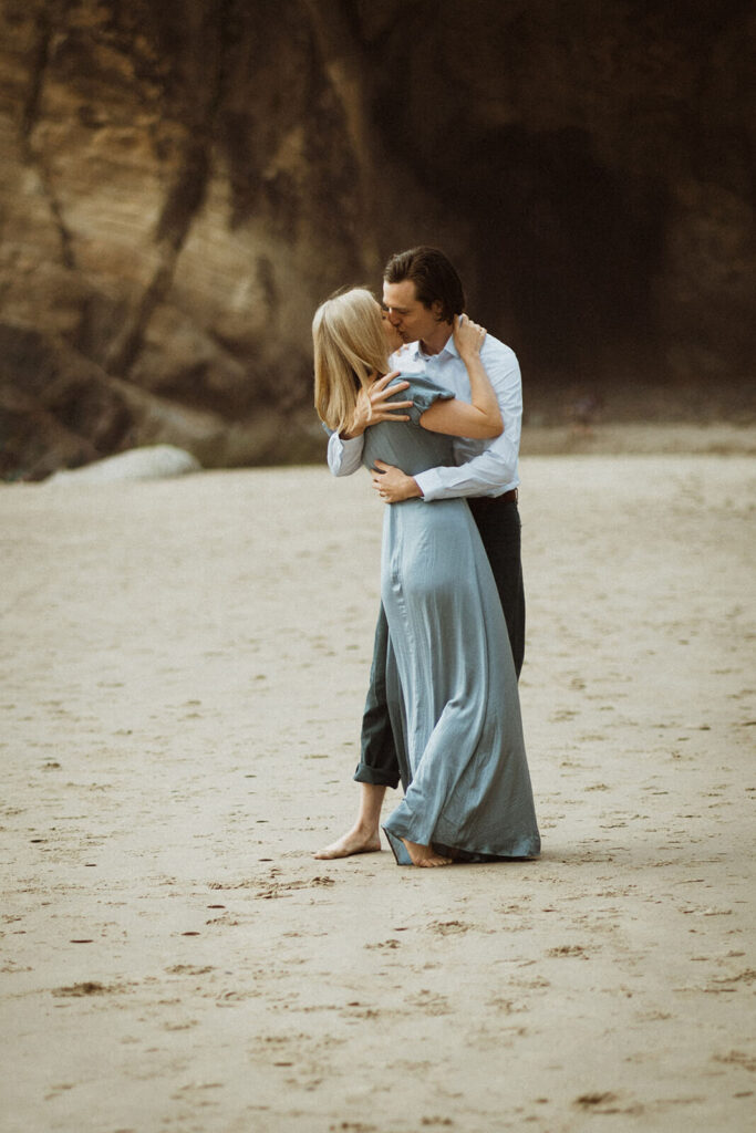 Couple kissing on the beach at Hug Point during engagement session