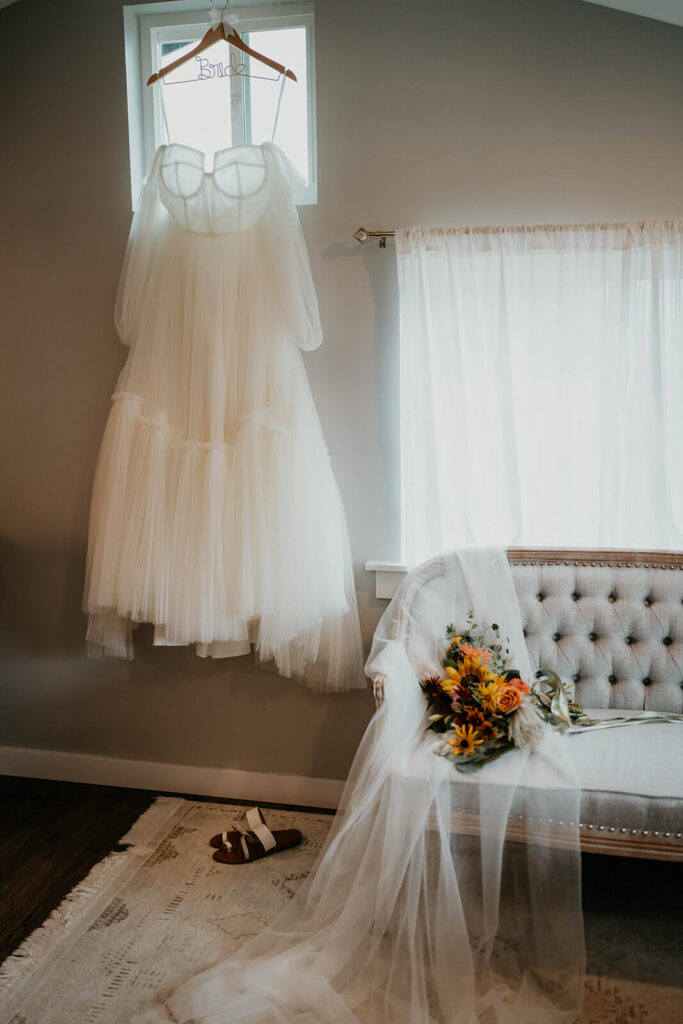 Romantic flowy wedding dress hanging from custom bride hangar