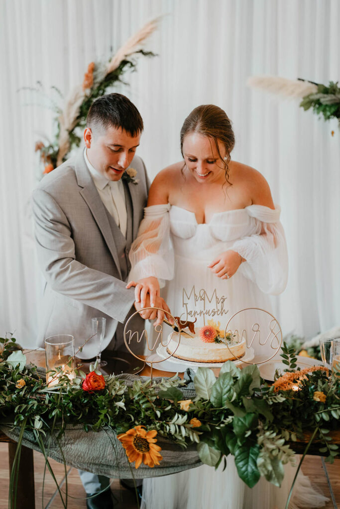 Bride and groom cut cake at Pemberton Farm wedding reception