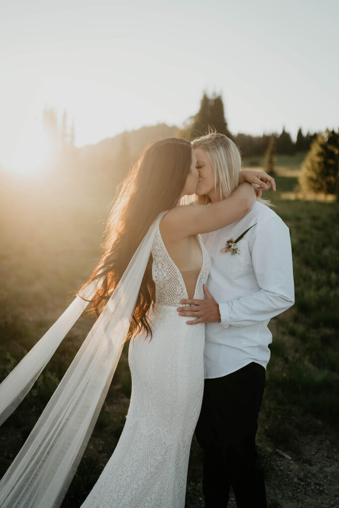 Two brides kissing during Sunrise, Mount Rainier elopement