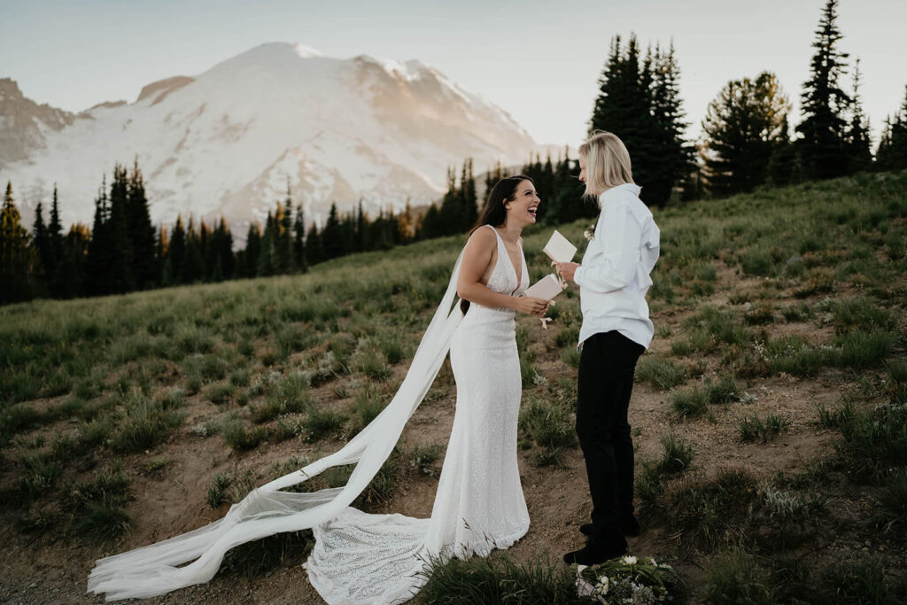 Two brides laughing during Sunrise, Mount Rainier elopement vow exchange