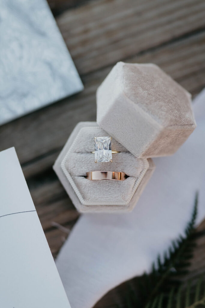 Emerald cut and rose gold wedding rings in pink ring box