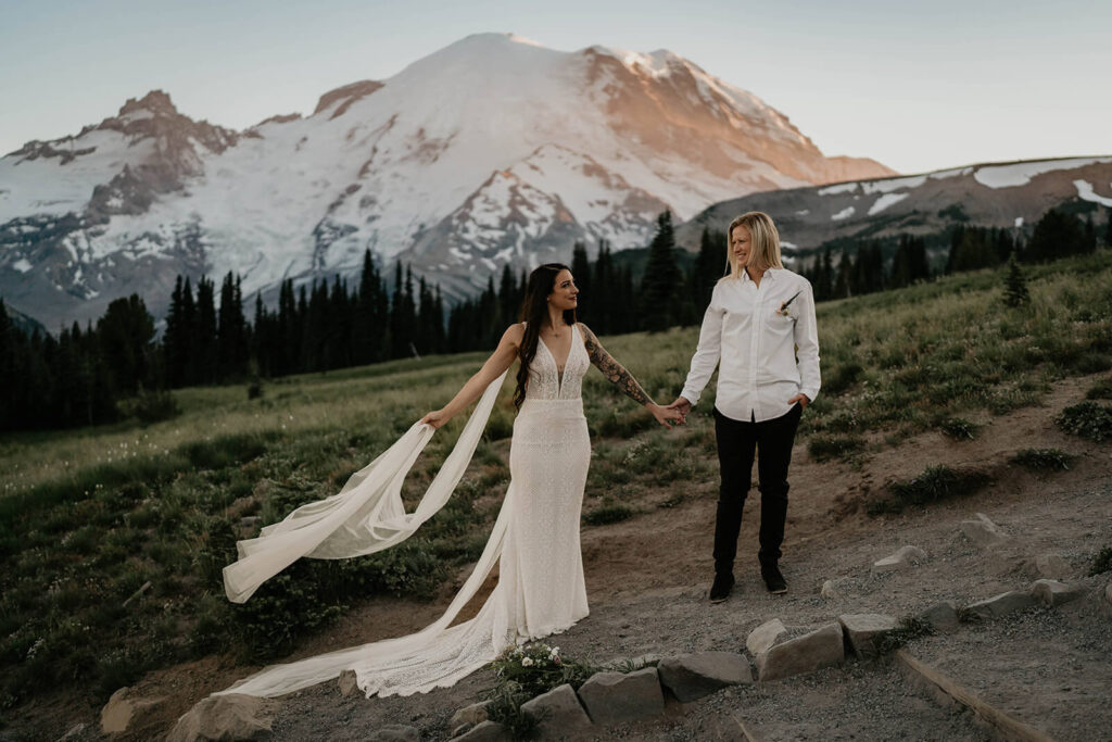 Two brides holding hands on a trail at Sunrise, Mt Rainier