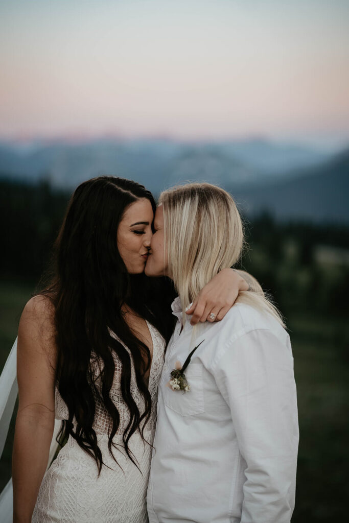 Brides kiss during couple portraits at Mt Rainier