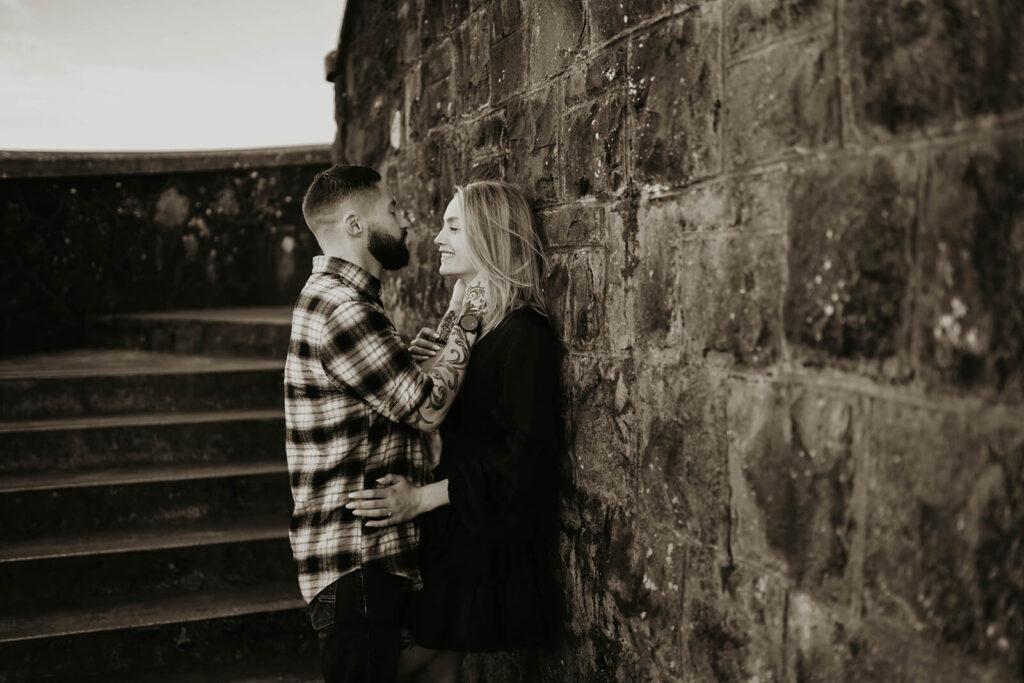 Couple leaning up against a wall during their engagement photos in Portland