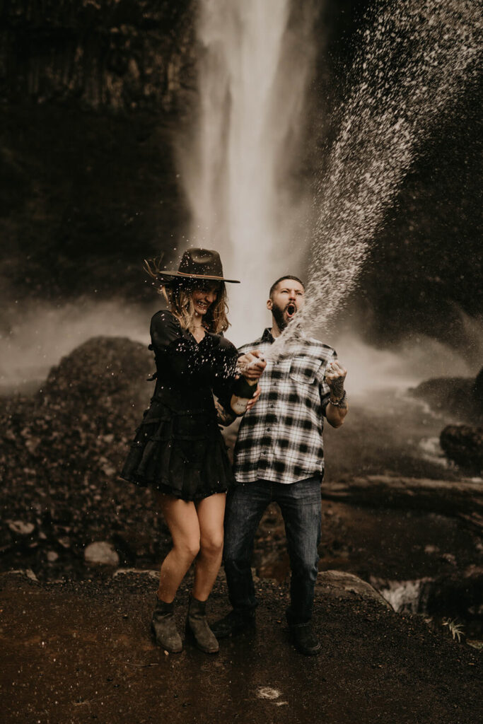 Couple spraying champagne during winter engagement photos in Oregon