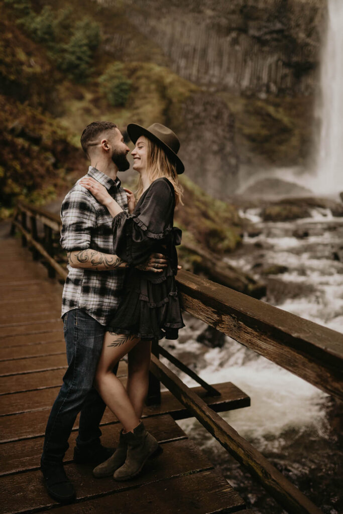 Couple standing on a bridge at Latourell Falls for their winter engagement photos