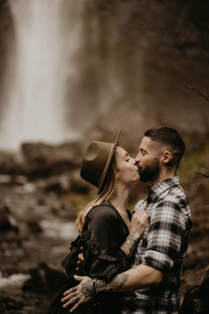 Couple kissing in front of Latourell Falls for their Oregon engagement photos