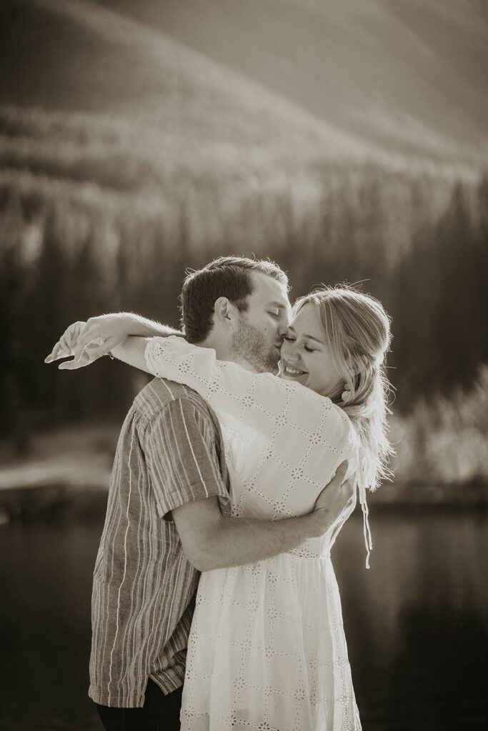 Man and woman hugging and kissing during adventure engagement photo session in Canada