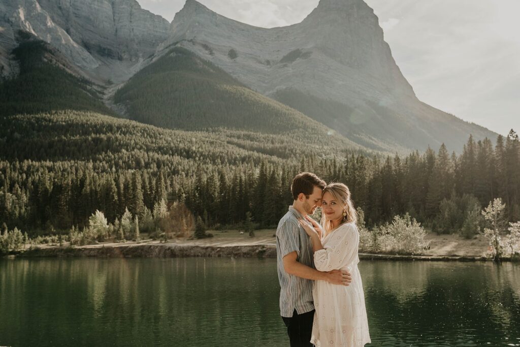 Couple hugging and smiling during outdoor adventure engagement photos in Banff, Canada