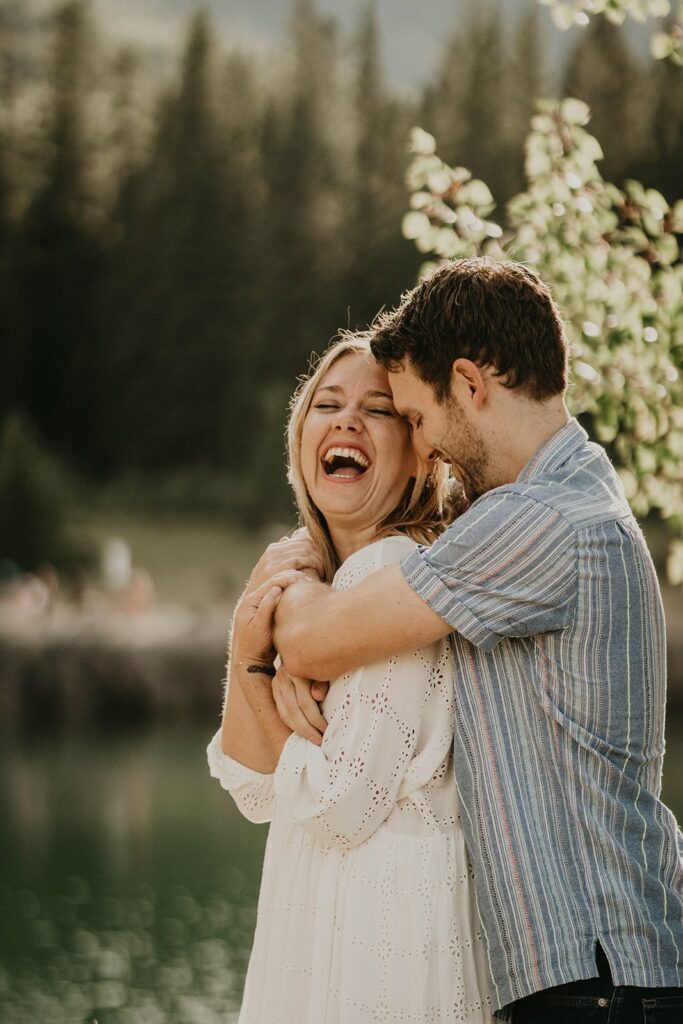 Couple hugging and laughing during mountain engagement photos in Banff, Canada