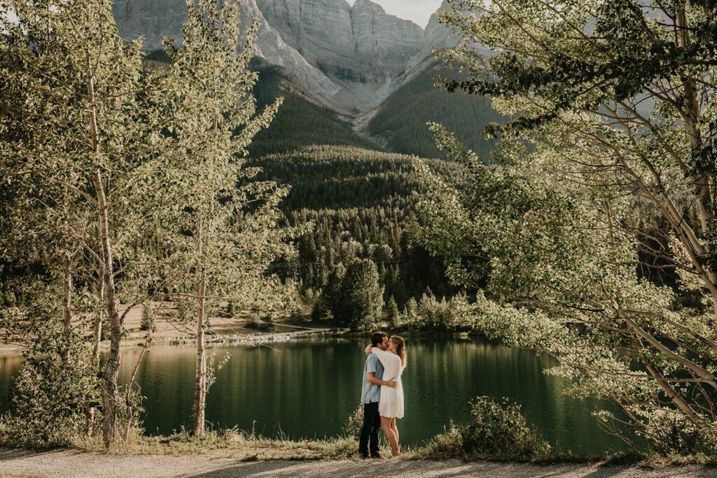 Couple kissing by the lake during mountain engagement photos session in Canada