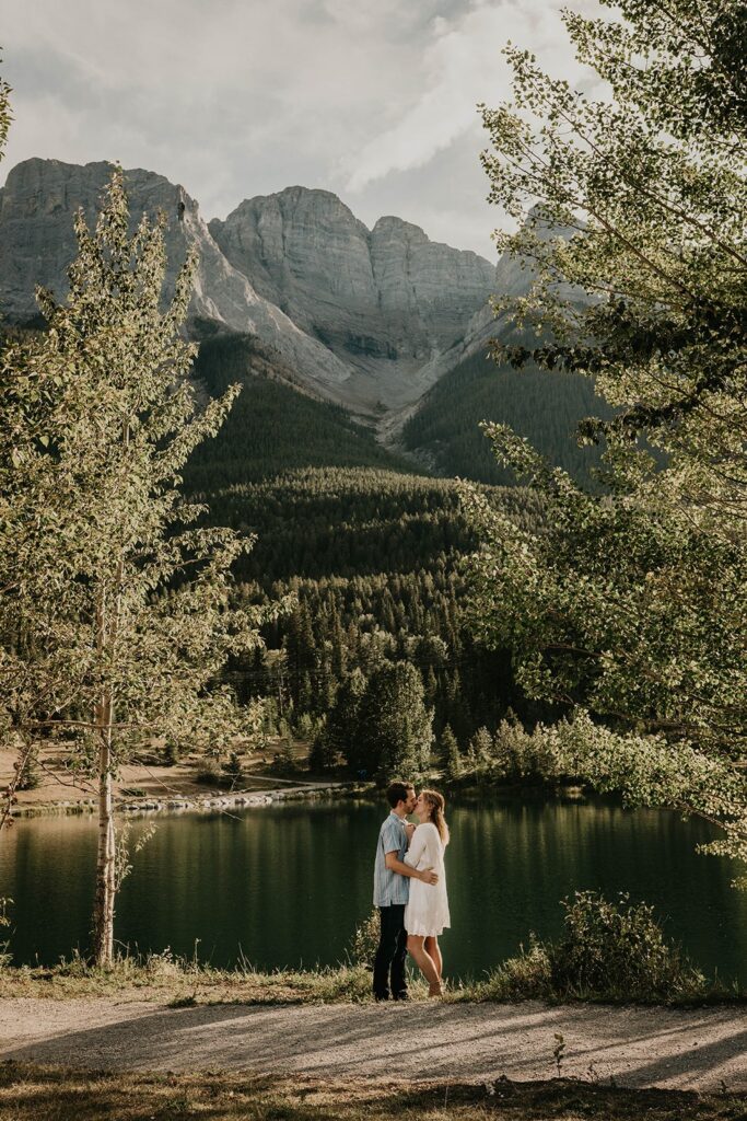 Couple kissing by the lake during adventure engagement photos session in Banff