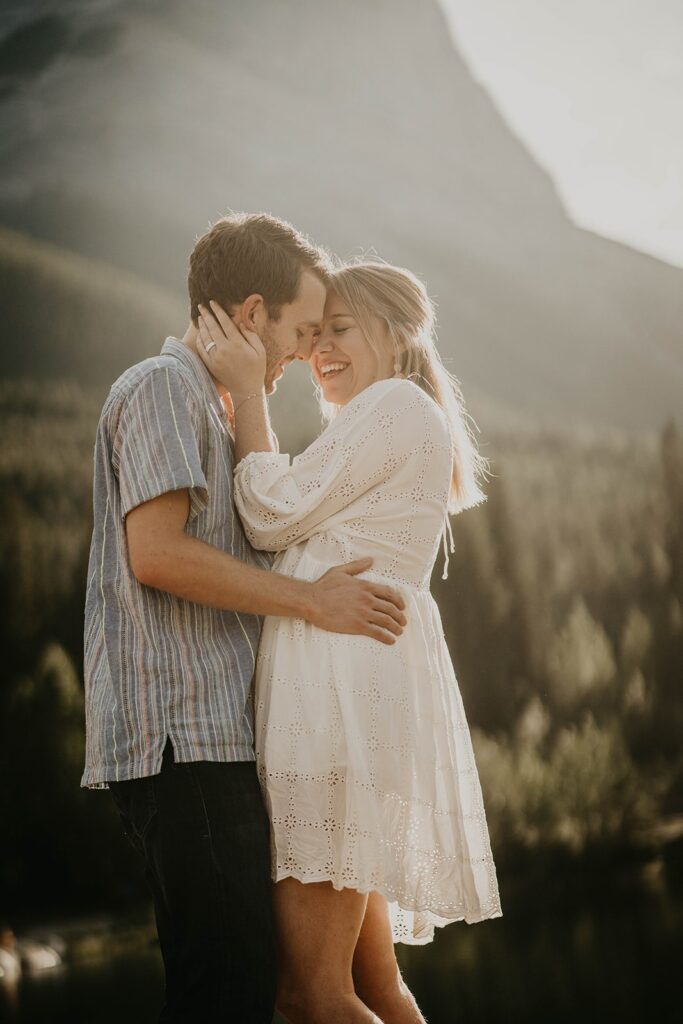 Man and woman hugging during engagement photo session in the mountain in Banff, Canada
