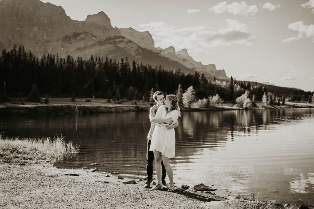 Couple hugging by the lake during summer engagement photos in Banff, Canada