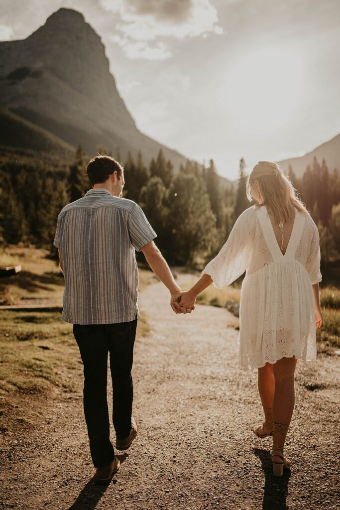 Man and woman walking hand in hand during their adventure engagement photos in Banff