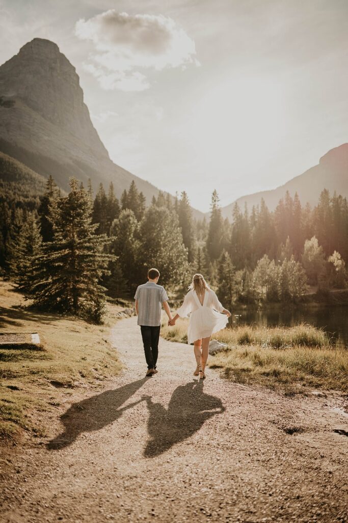 Man and woman walking hand in hand on a trail in Banff, Canada