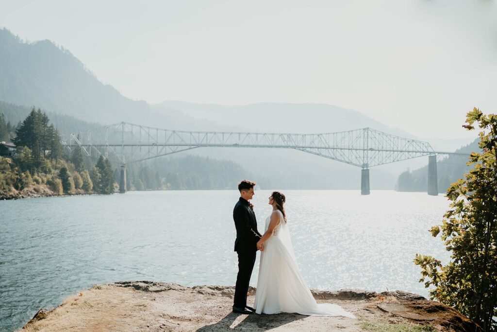 Bride and groom hold hands for wedding couple portraits at Cascade Locks