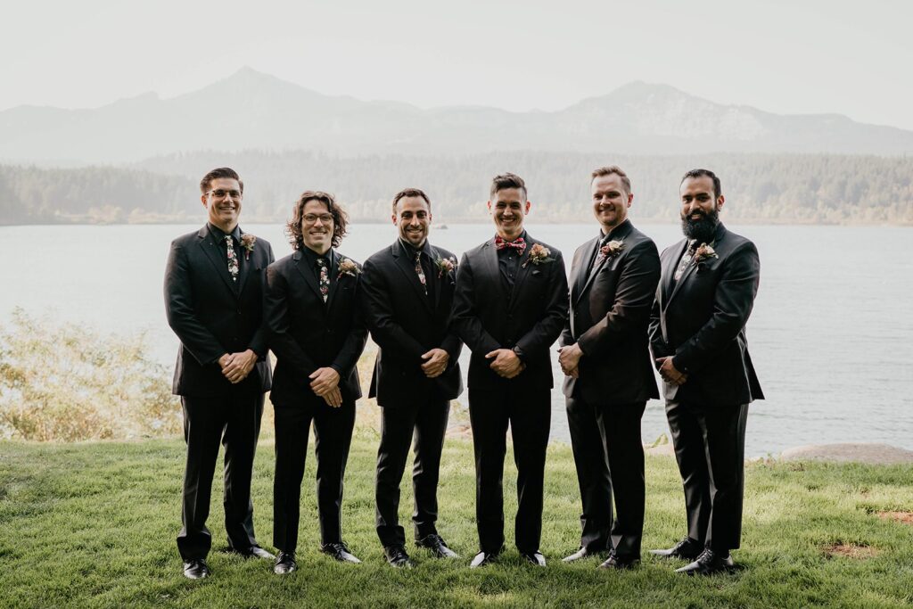 Wedding portraits by the Columbia River with groomsmen wearing all black suits