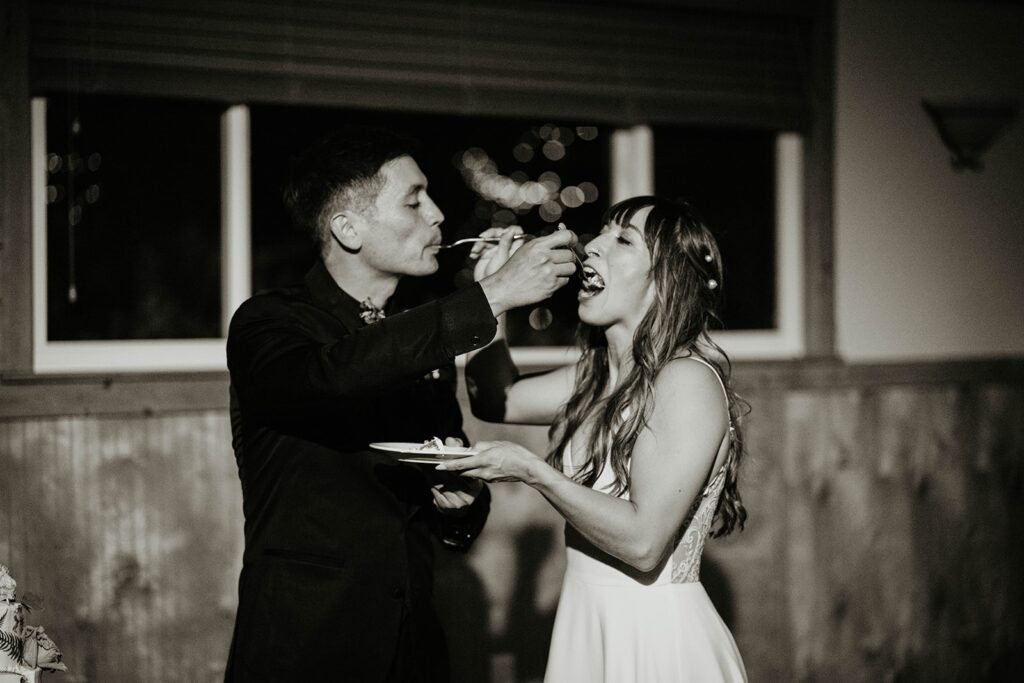 Bride and groom feed each other wedding cake at Thunder Island wedding reception