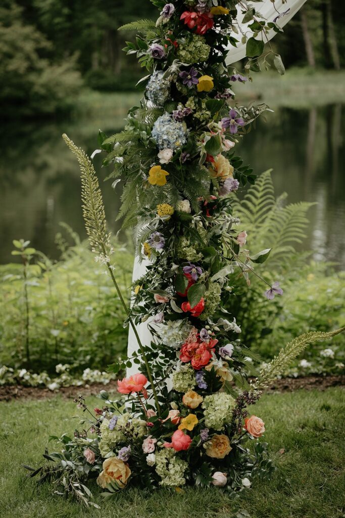 Colorful flowers decorating the wedding ceremony arch at outdoor wedding at Bridal Veil Lakes 