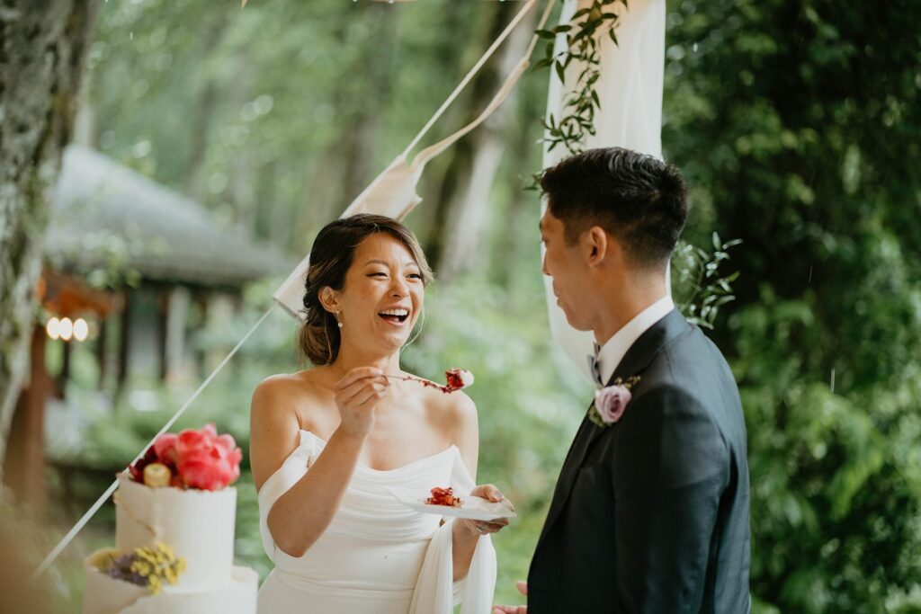 Bride feeds groom cake during Asian wedding reception 