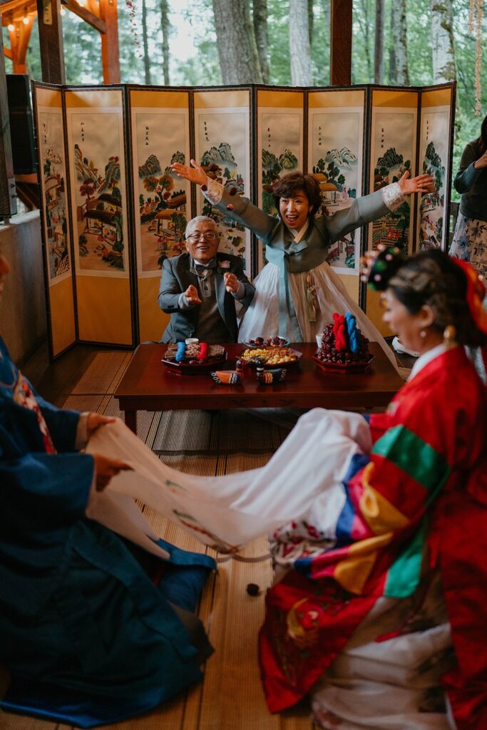 Bride and groom catch chestnuts during traditional Korean wedding ceremony