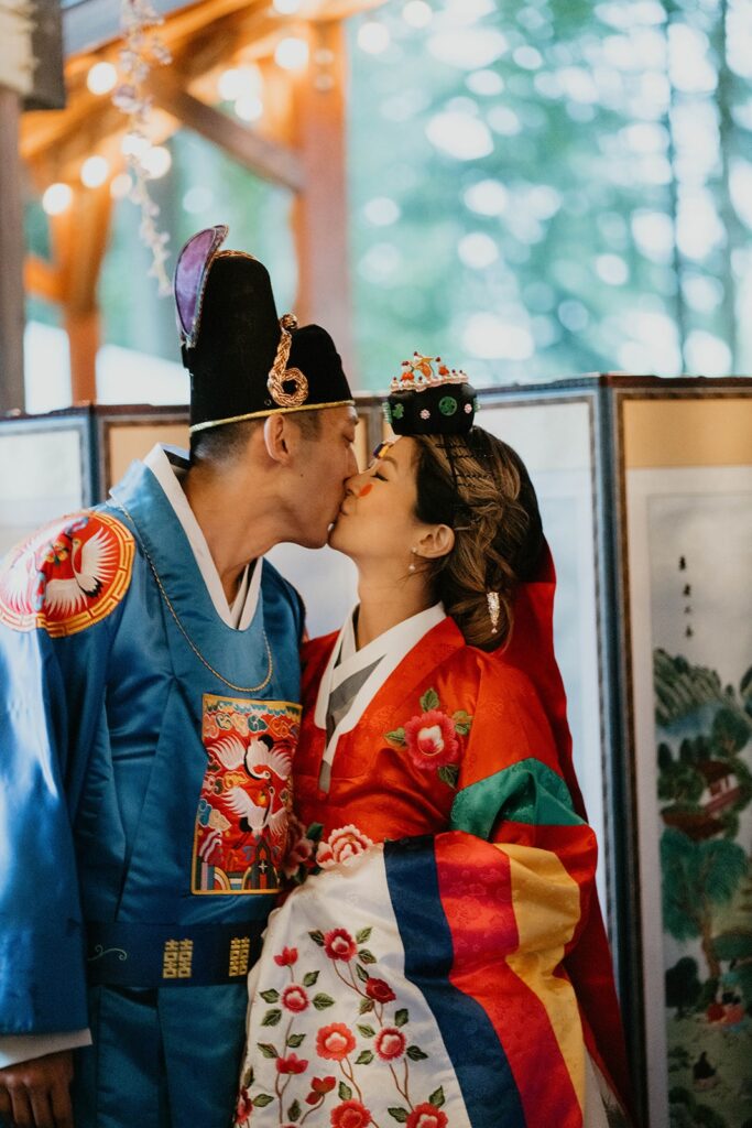 Bride and groom kiss after traditional Korean wedding ceremony