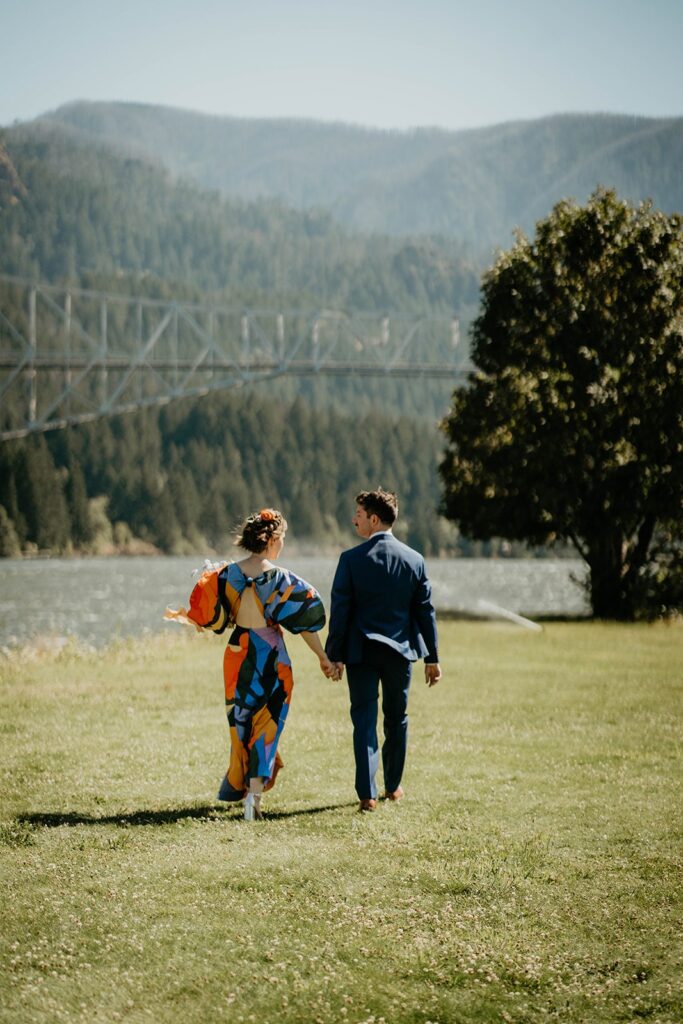 Bride and groom holding hands while walking on Thunder Island during their Cascade Locks wedding photos