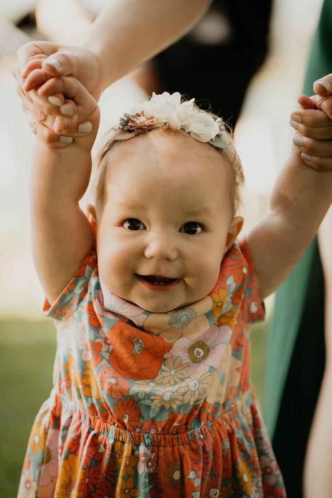 Baby wearing colorful dress with flowers at Cascade Locks wedding
