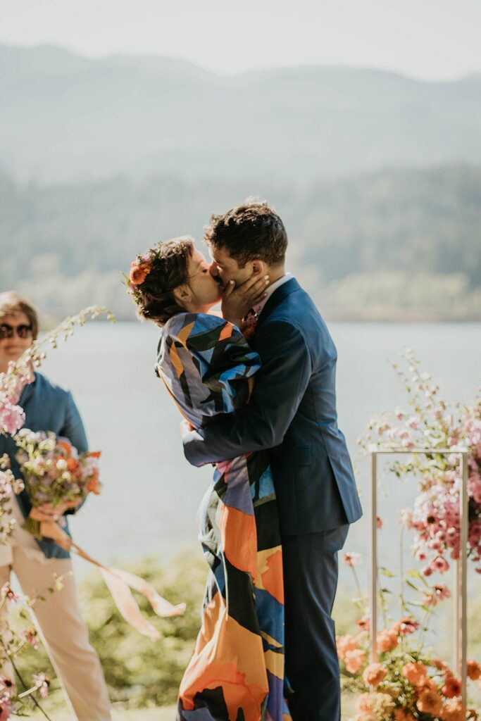 Bride and groom kiss during colorful Cascade Locks wedding