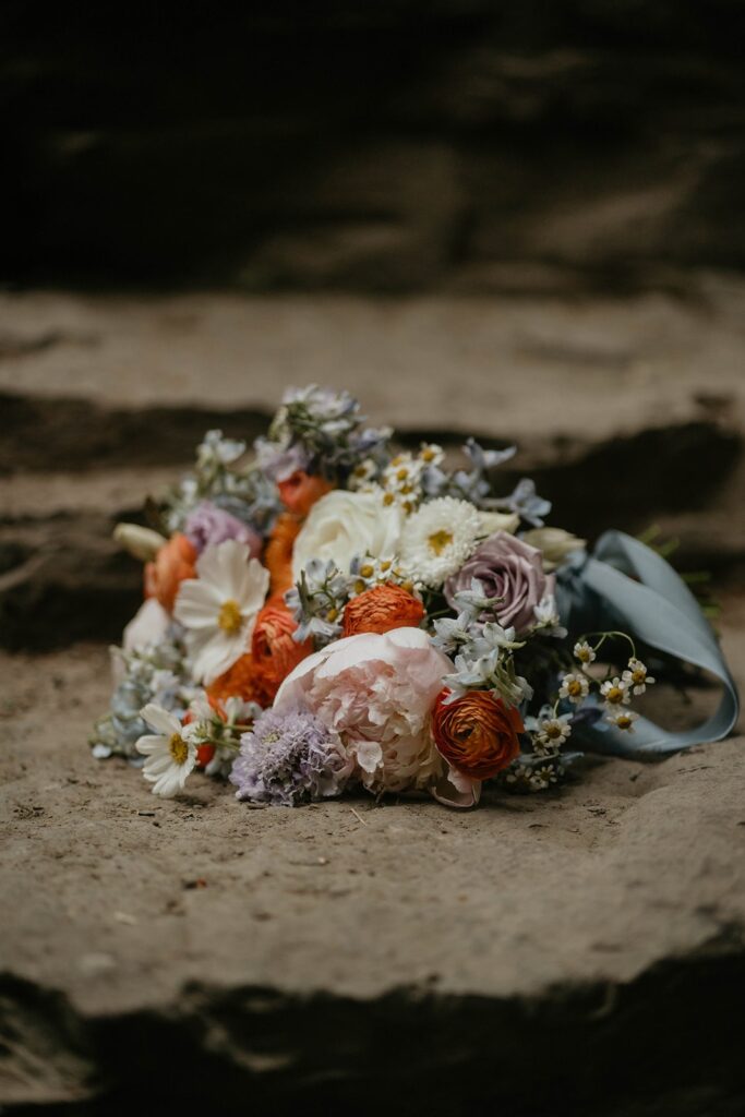Colorful wedding bouquet with white, purple, and orange flowers