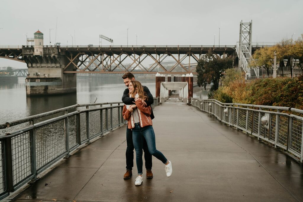 Couple walking on a boardwalk during their engagement photos in Portland, Oregon