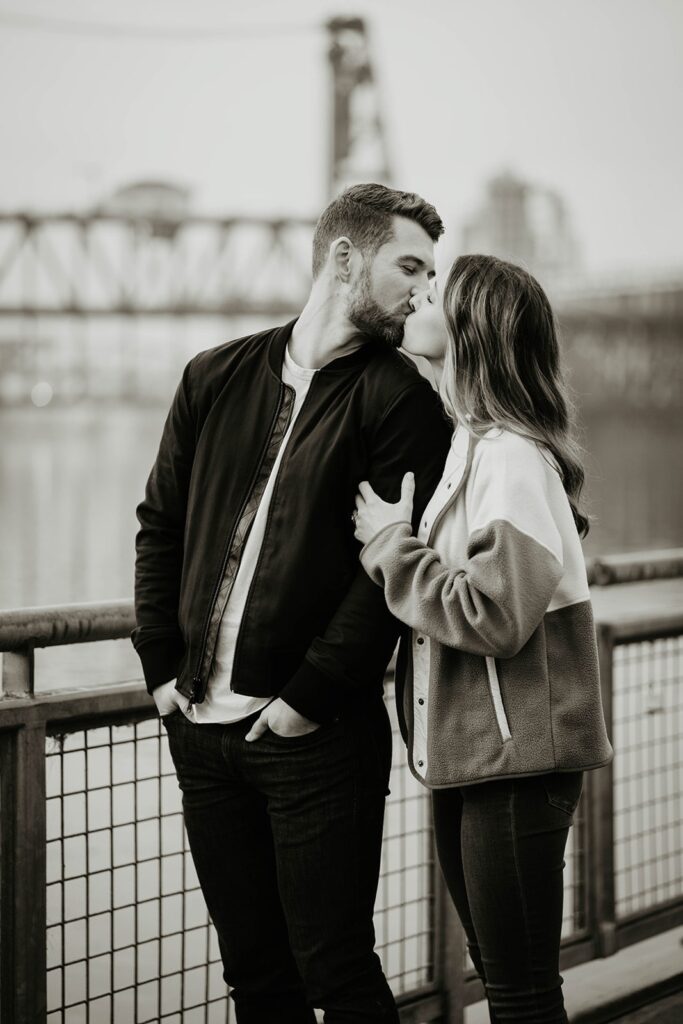 Couple kissing during Portland engagement photo session by the river