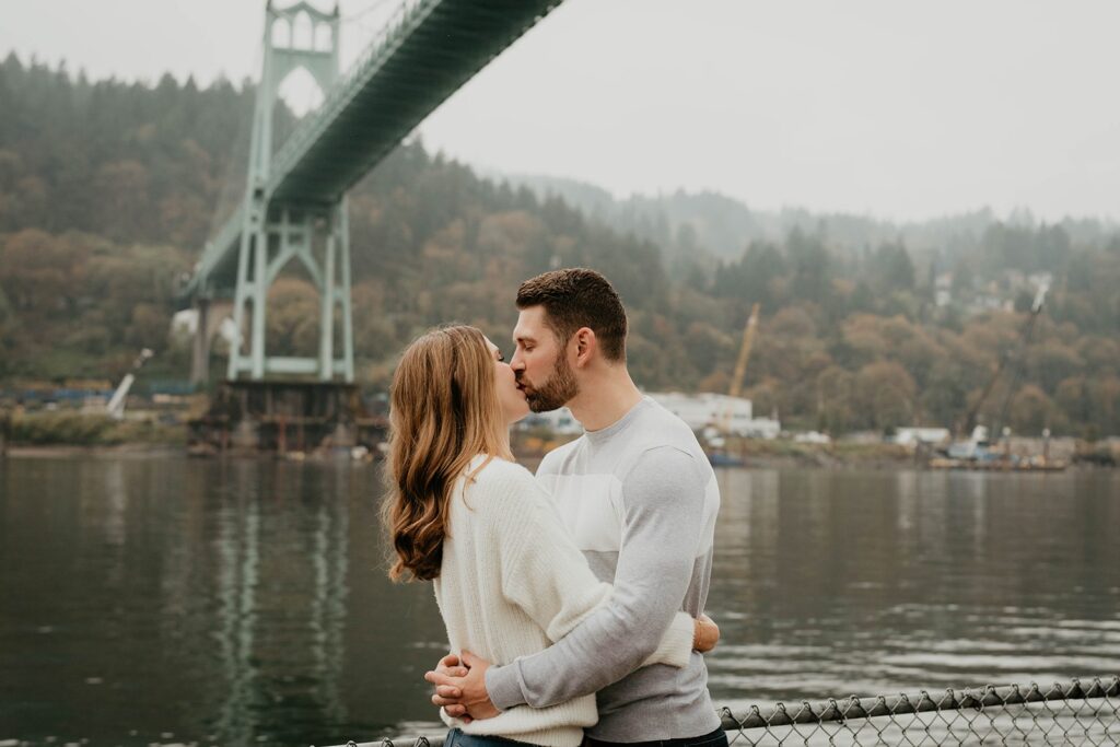 Couple kissing on the dock at their downtown Portland engagement photoshoot