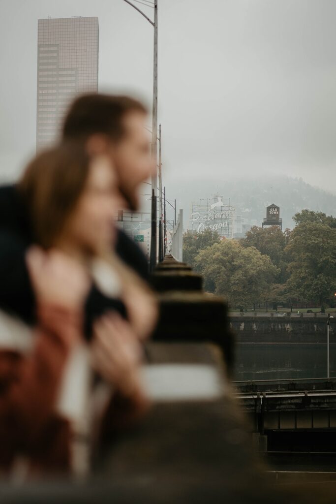 Couple standing on a bridge during their engagement photos in Portland, Oregon