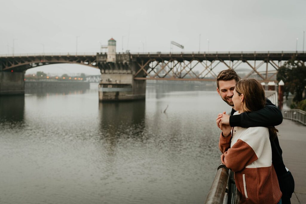 Couple overlooking the river during their engagement photos in Portland, Oregon
